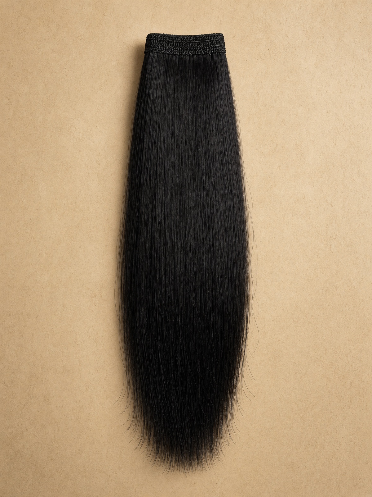 Sleek straight human hair weft hanging in studio light